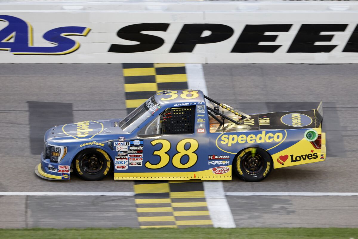 Zane Smith (38) crosses the finish line to win the second stage of a NASCAR Truck Series auto race at Kansas Speedway in Kansas City, Kan., Saturday, May 14, 2022. (AP Photo/Colin E. Braley)