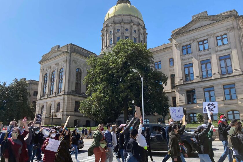 Hundreds of people gather in a park across from the Georgia state Capitol in Atlanta to demand justice for the victims of shootings at massage businesses days earlier, Saturday, March 20, 2021 in Atlanta. (AP Photo/Candice Choi)