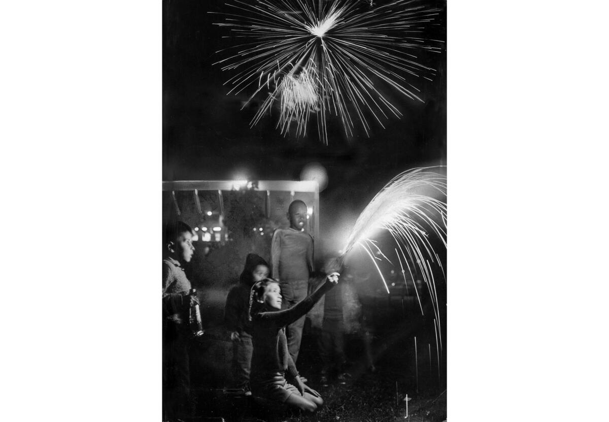 July 4, 1966: Children celebrate the Fourth of July on the lawn outside the Memorial Coliseum while a fireworks show goes on overhead.