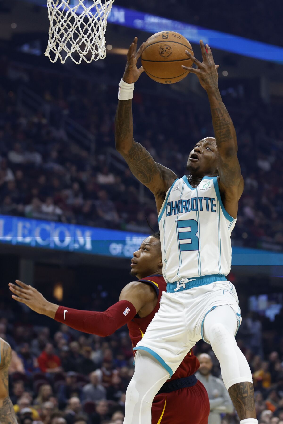 Charlotte Hornets' Terry Rozier (3) grabs a rebound against Cleveland Cavaliers' Isaac Okoro (35) during the first half of an NBA basketball game, Wednesday, March 2, 2022, in Cleveland. (AP Photo/Ron Schwane)