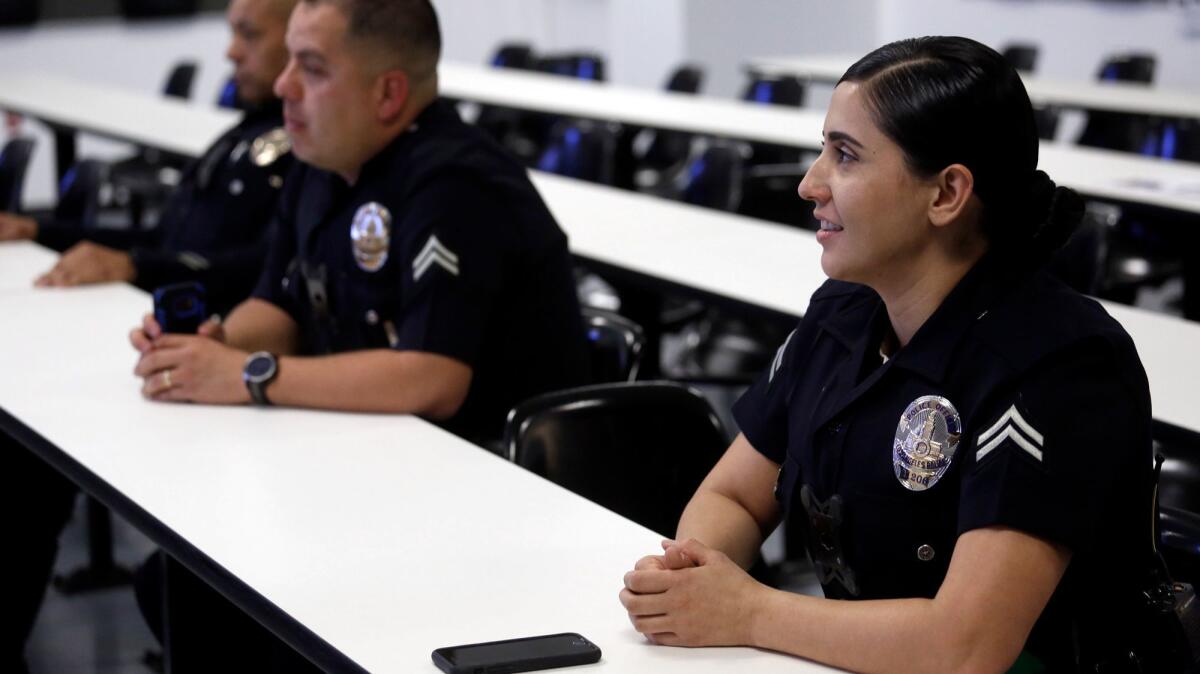 Los Angeles Police Officer Nancy Rodriguez, right, attends roll call at the Olympic Station in Los Angeles.