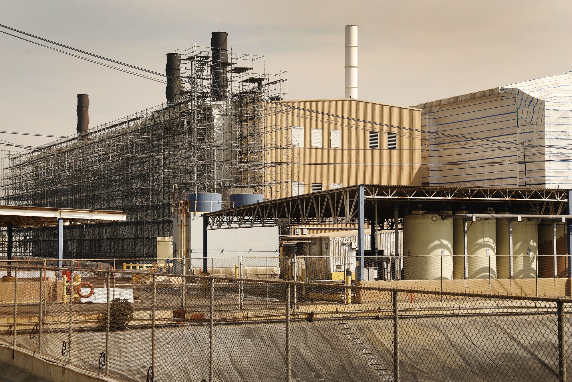 Smokestacks rise from an industrial facility.