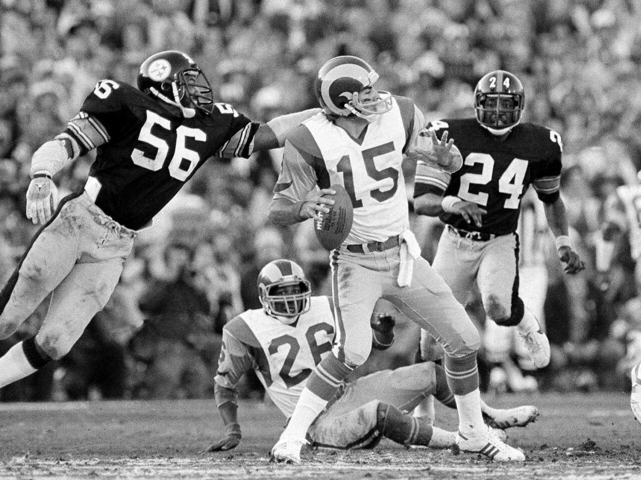 Rams quarterback Vince Ferragamo (15) prepares to pass but never gets the ball past Steelers' Robin Cole (56), during Super Bowl XIV action at the Rose Bowl in Pasadena on Jan. 21, 1980. Ferragamo is sacked on the play. The Rams lost to the Steelers, 31-19.