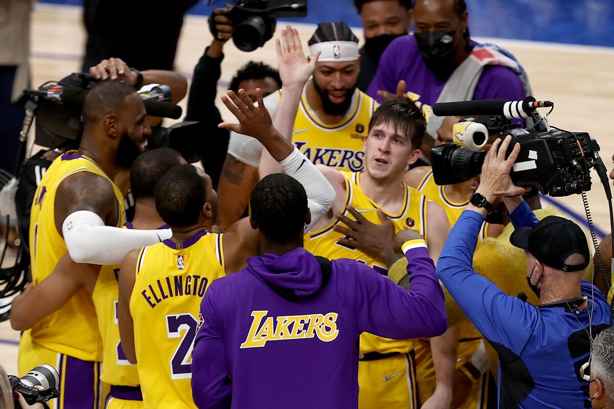 Austin Reaves is congratulated by teammates after hitting a game-winning shot against the Mavericks