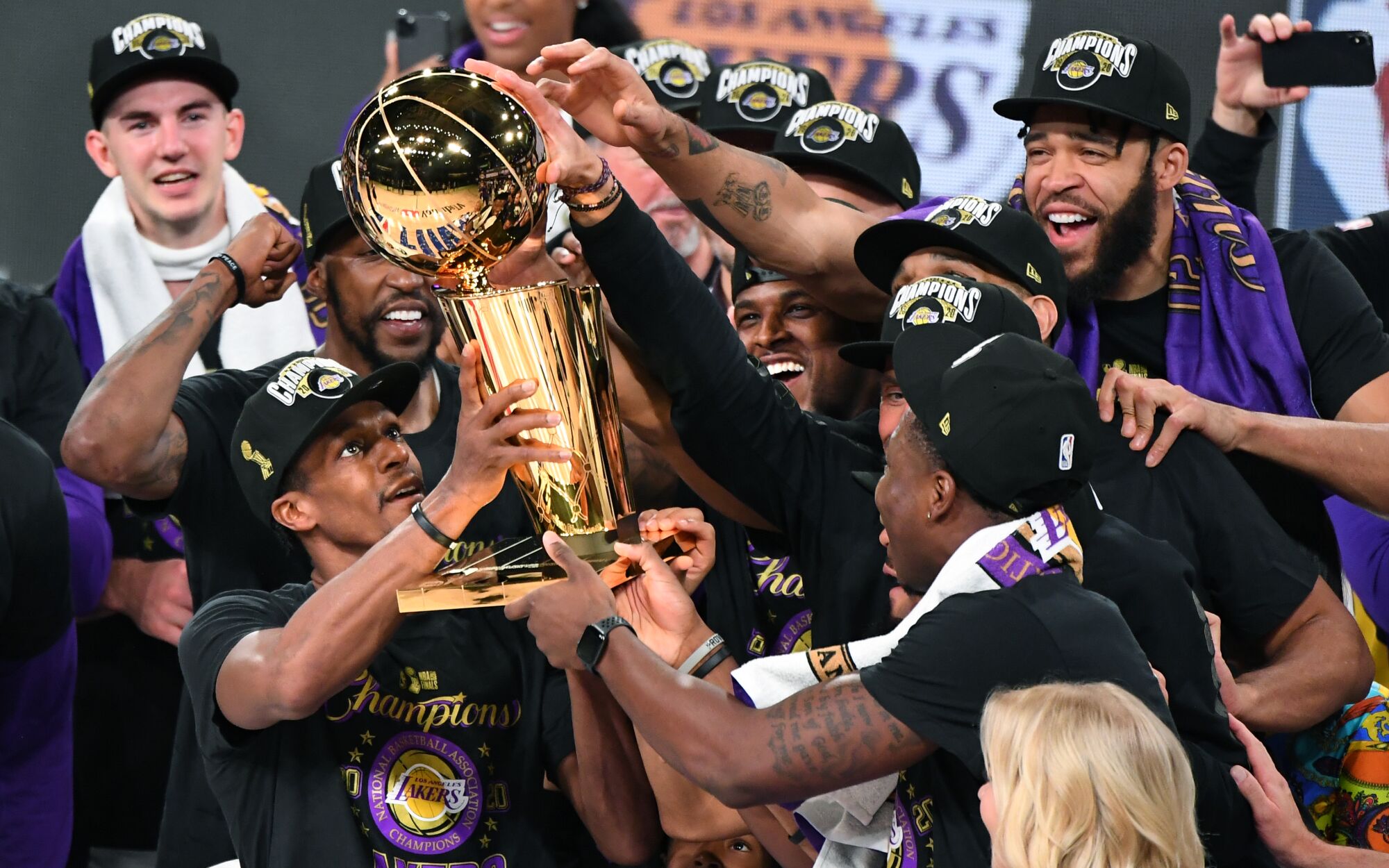 Lakers players lift the Larry O'Brien trophy after winning the NBA title.
