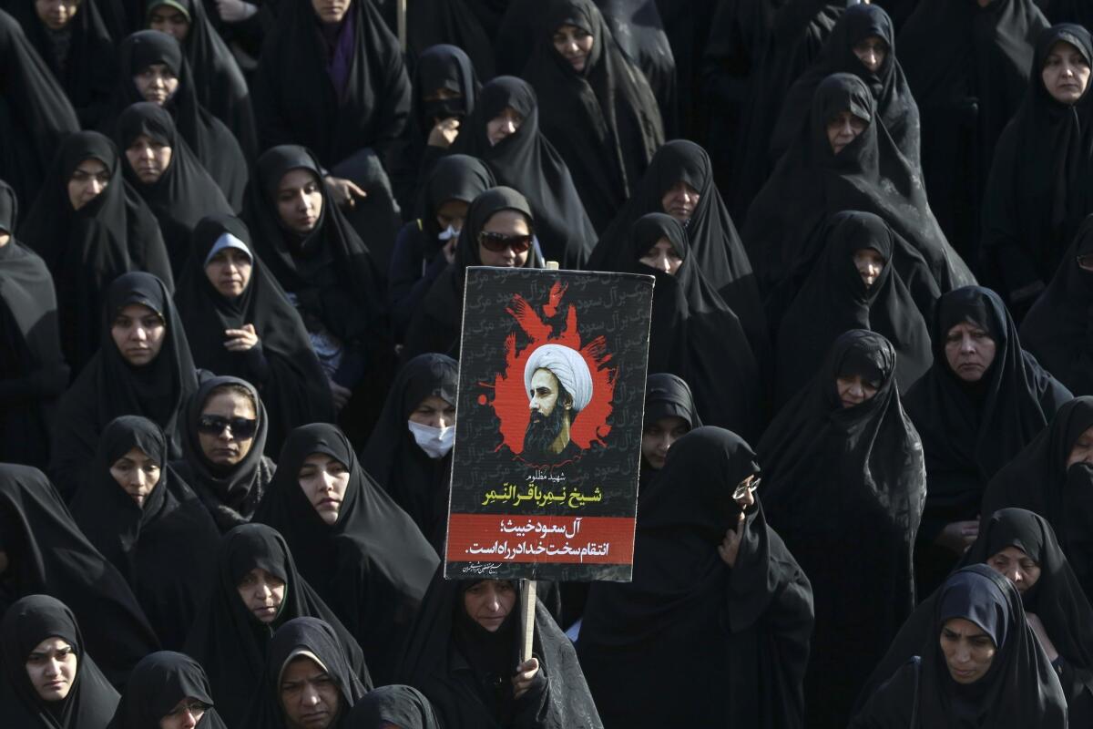 An Iranian woman in Tehran on Monday holds up a poster showing Sheikh Nimr Al-Nimr, a prominent opposition Saudi Shiite cleric who was executed last week by Saudi Arabia.