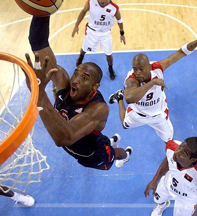 Team USA forward Kobe Bryant goes for a dunk as Angola players Armando Costa (5), Vladimir Jeronimo (9) and Carlos Morais (6) look on during their preliminary basketball game in Beijing. The U.S. won, 97-76.