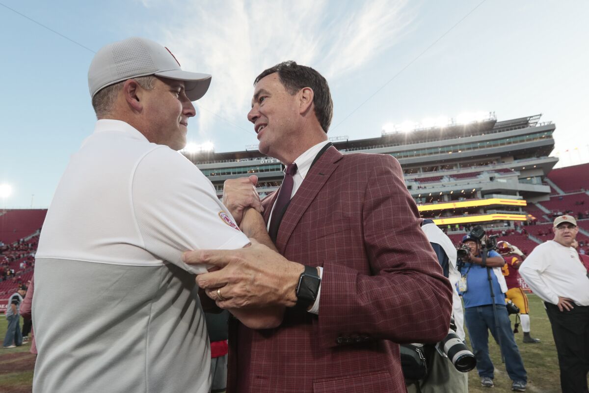 USC football coach Clay Helton is congratulated by athletic director Mike Bohn.