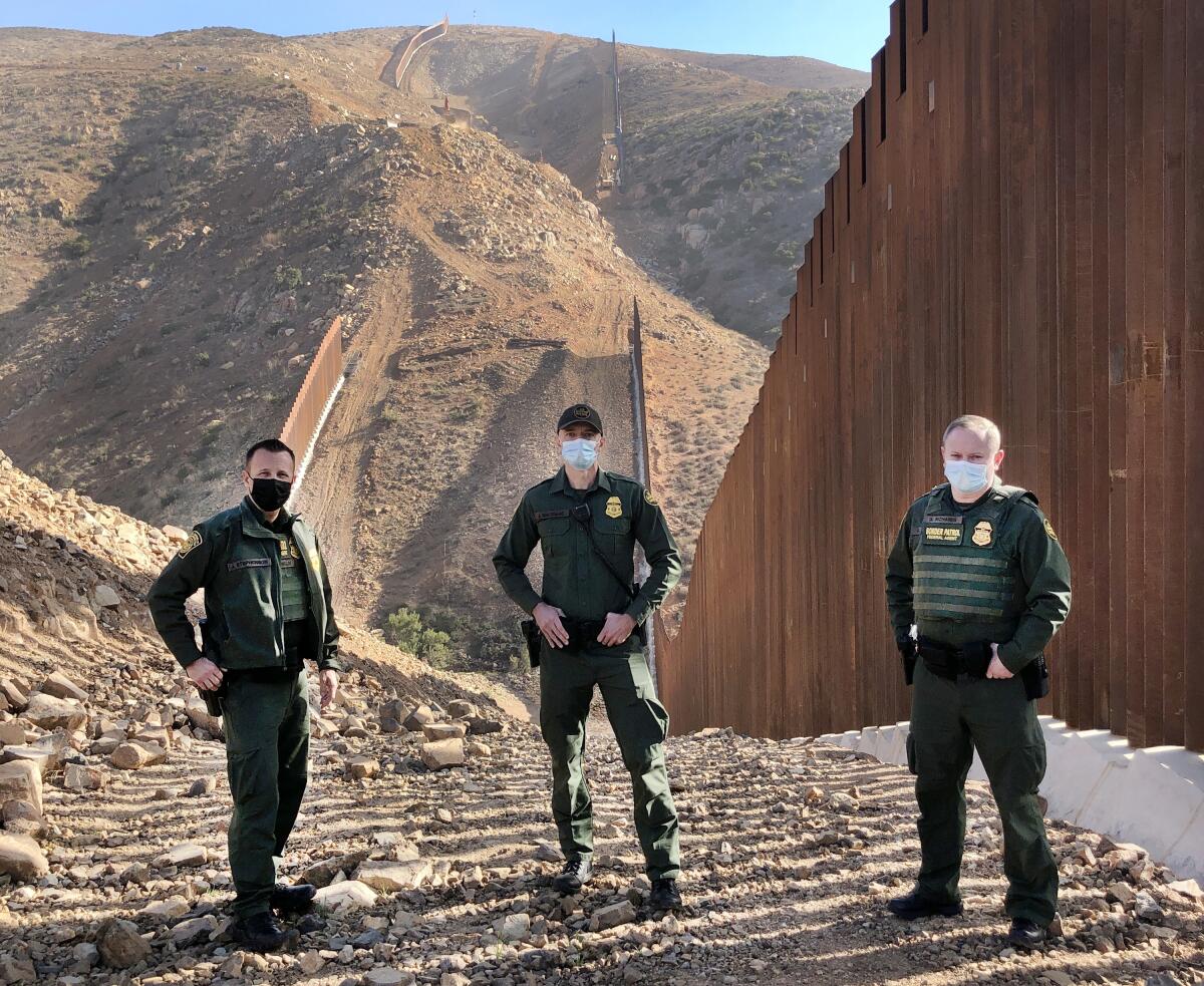 Border Patrol Agents Jeff Stephenson, Jacob MacIsaac, and Gary Richards of San Diego stand before underway construction.