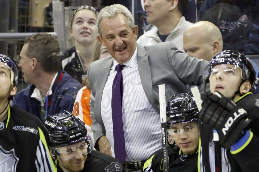 Kings Coach Darryl Sutter stands behind his bench during the second period of the NHL All-Star game on Jan. 25.