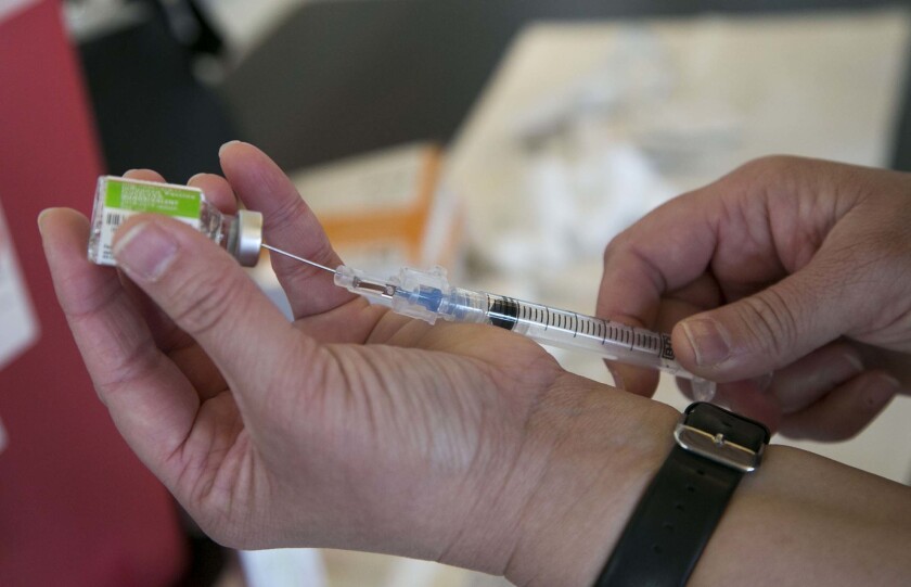 A staff member at the Sharp Senior Satellite Health Center prepares a flu vaccine dose on Oct. 19, 2018.