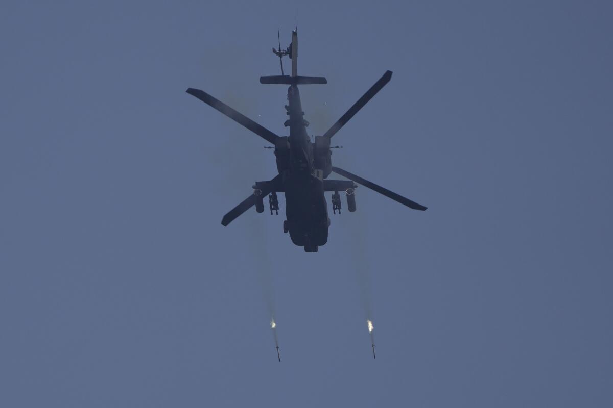 U.S. Army AH-64 Apache attack helicopter firing rockets