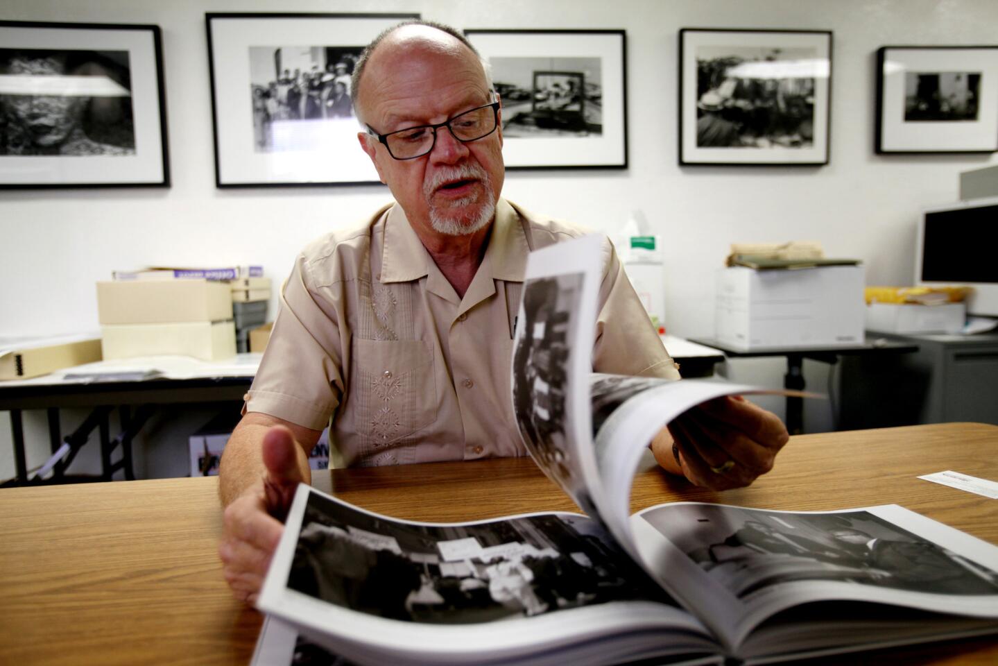 Cal State Northridge journalism professor R. Kent Kirkton leafs through a book spotlighting African American photography as he speaks with reporters on campus.