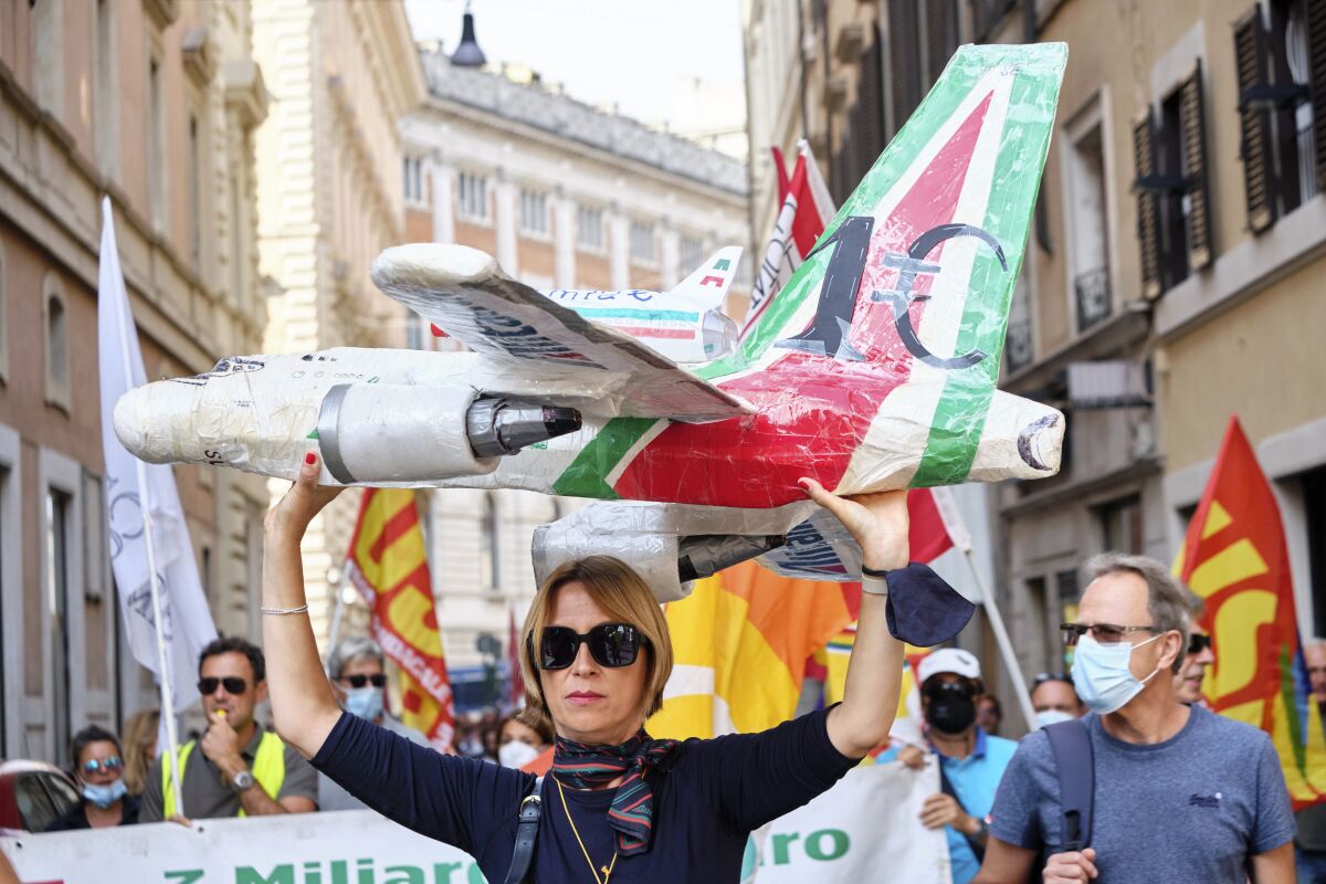 Workers of former Italian national flag carrier Alitalia demonstrate outside the Italian Parliament in downtown Rome, Friday, Sept. 10, 2021. The European Union’s competition watchdog on Friday cleared an injection of Italian government funds into new national flag carrier ITA, and said the company would not be held accountable for illegal state aid given to its predecessor Alitalia. (Mauro Scrobogna /LaPresse via AP)