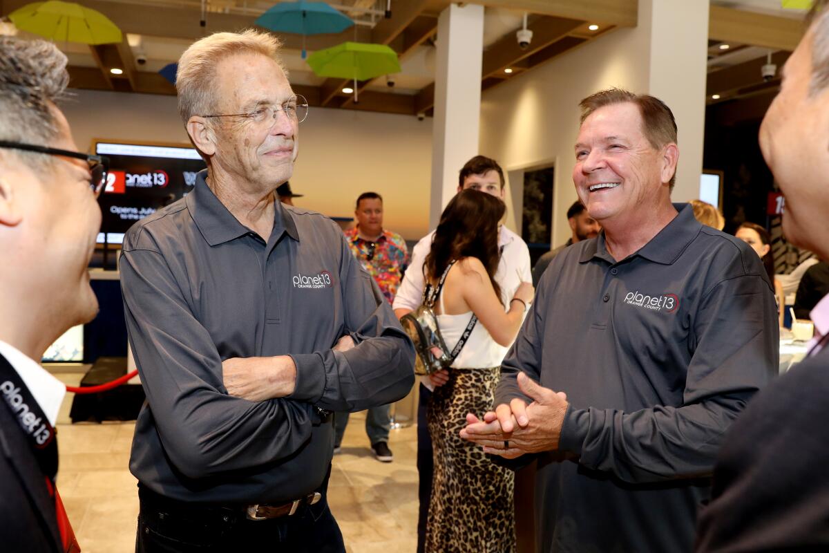 Two men in gray shirts having a conversation.