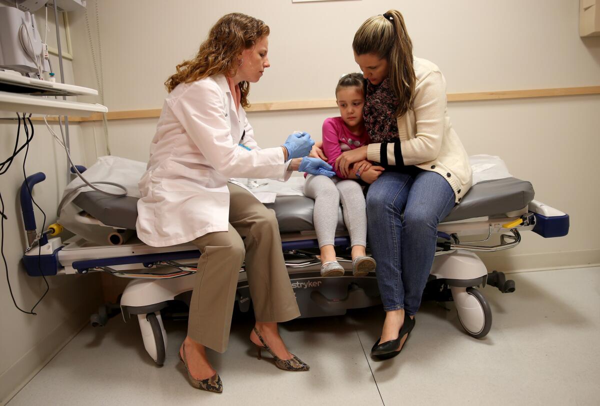 This won't hurt a bit: pediatrician Amanda Porro administers a measles shot to Sophie Barquin, 4, at Miami Children's Hospital.