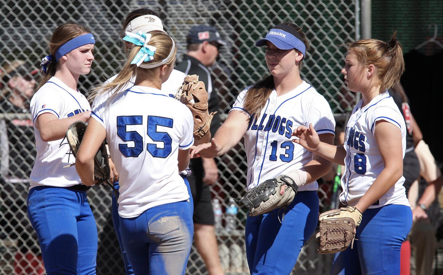 Burbank pitcher Caitlyn Brooks gets congratulated by her teammates after striking out a Glendale player during a game on Tuesday, May 13, 2014.