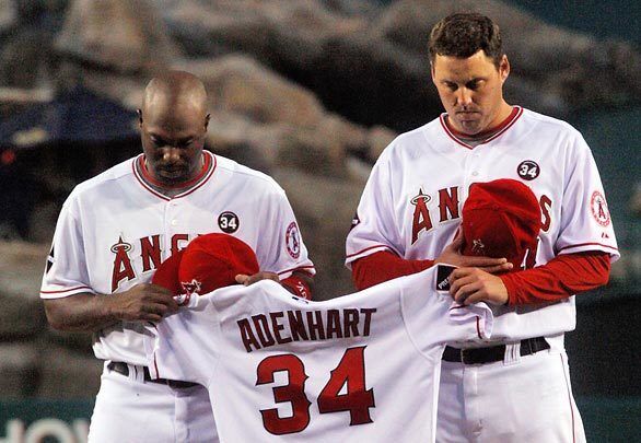 Angels Torii Hunter and John Lackey hold the jersey of pitcher Nick Adenhart, who died of injuries suffered in a car accident Thursday.