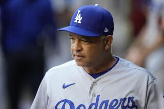 Dodgers manager Dave Roberts pauses in the dugout before a playoff game against the Arizona Diamondbacks on Oct. 11, 2023.