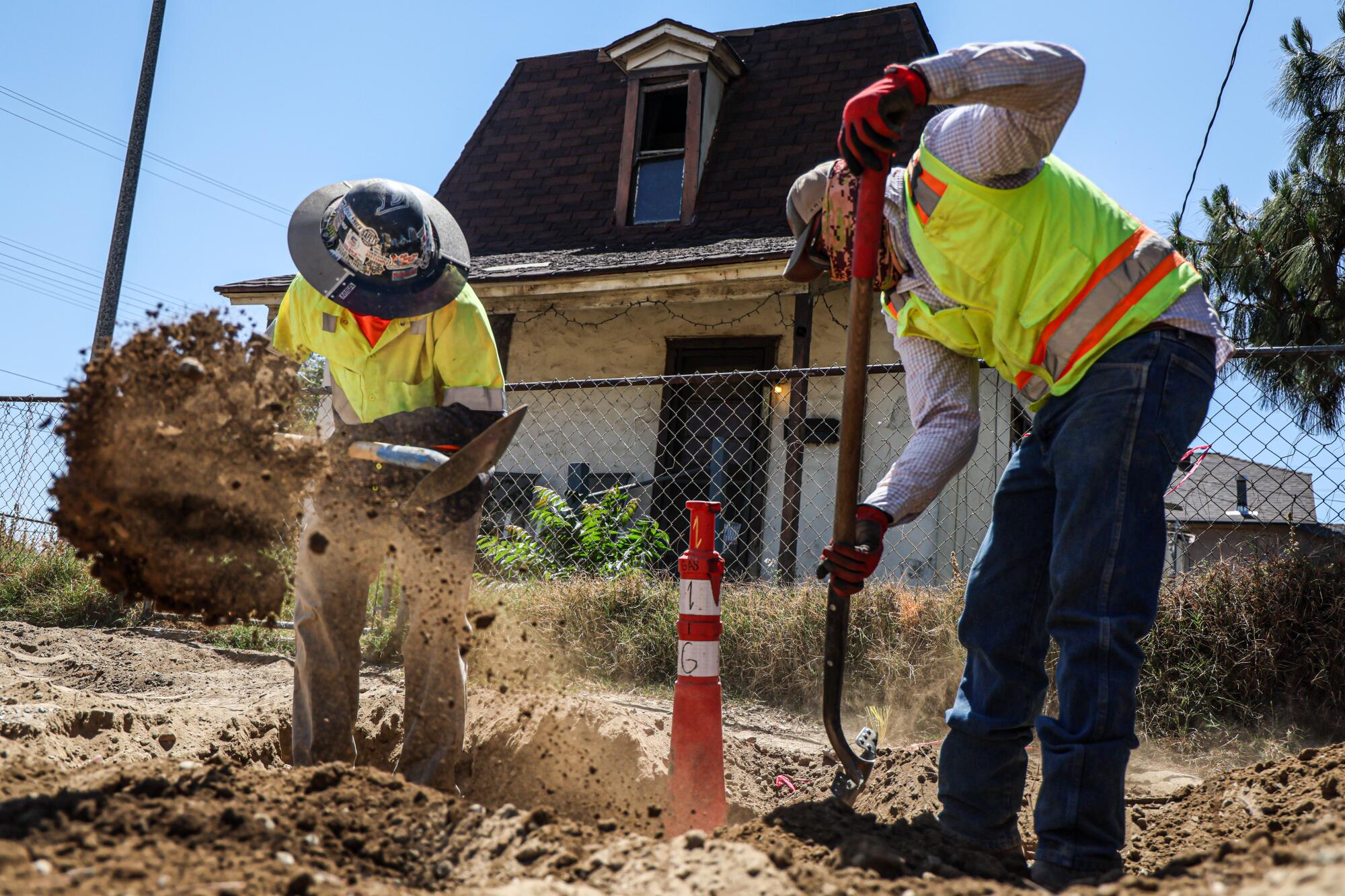 Construction employees Joey Navarro, left, and Juan Villegas work in Pomona in May.