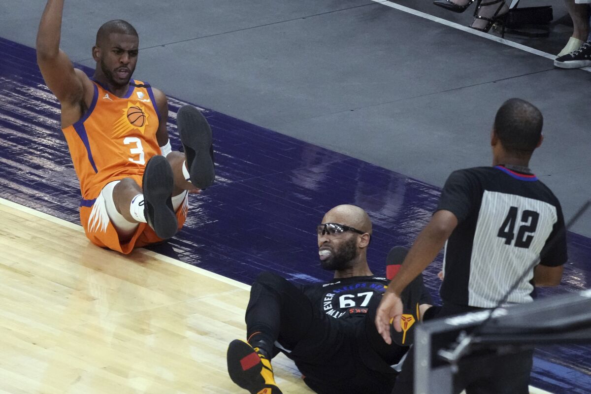 Phoenix Suns guard Chris Paul (3) reacts after getting knocked to the floor by New York Knicks center Taj Gibson (67) during the second half of an NBA basketball game Friday, May 7, 2021, in Phoenix. (AP Photo/Rick Scuteri)