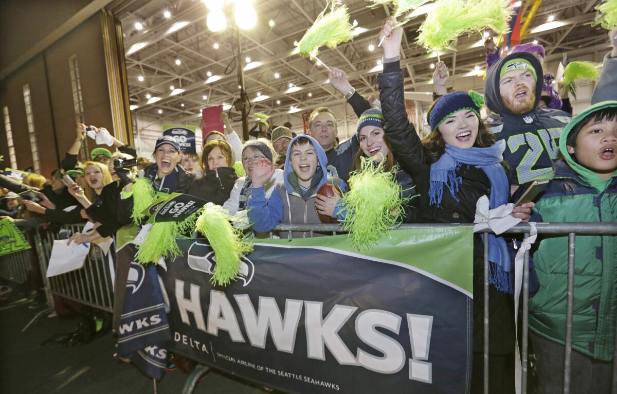 Fans greet the Super Bowl-winning Seattle Seahawks during the team's arrival at Seattle-Tacoma International Airport on Monday.