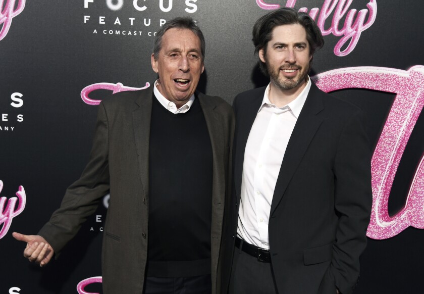 FILE - Director Jason Reitman, right, and his father Ivan Reitman arrive at the Los Angeles premiere of "Tully" at Regal Cinemas L.A. Live on Wednesday, April 18, 2018. Ivan Reitman, the influential filmmaker and producer behind beloved comedies from “Animal House” to “Ghostbusters,” has died. Reitman passed away peacefully in his sleep Saturday night, Feb. 12, 2022, at his home in Montecito, Calif., his family told The Associated Press. He was 75. (Photo by Chris Pizzello/Invision/AP, File)