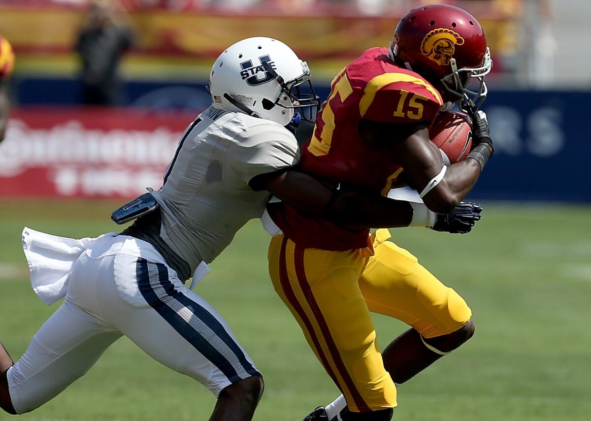 USC receiver Nelson Agholor makes a catch against Utah State cornerback Nevin Lawson in the first half Saturday at the Coliseum.