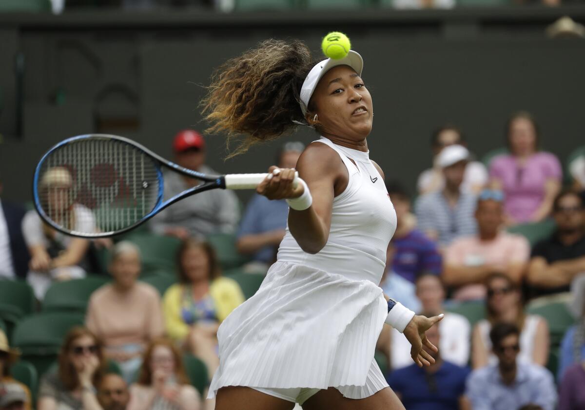 FILE - Japan's Naomi Osaka returns to Kazakstan's Yulia Putintseva in a women's singles match during day one of the Wimbledon Tennis Championships in London, in this Monday, July 1, 2019, file photo. Osaka’s agent says the four-time Grand Slam champion will sit out Wimbledon and compete at the Tokyo Olympics. Stuart Duguid wrote Thursday, June 17, 2021, in an email that Osaka “is taking some personal time with friends and family. She will be ready for the Olympics and is excited to play in front of her home fans.” (AP Photo/Kirsty Wigglesworth, File)