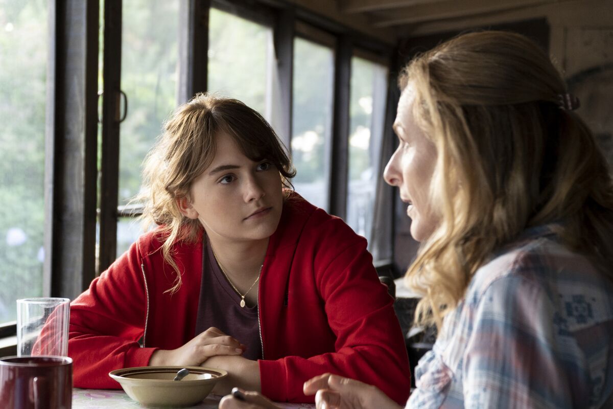 Emilia Jones and Marlee Matlin sit at a table in a scene from "CODA." 