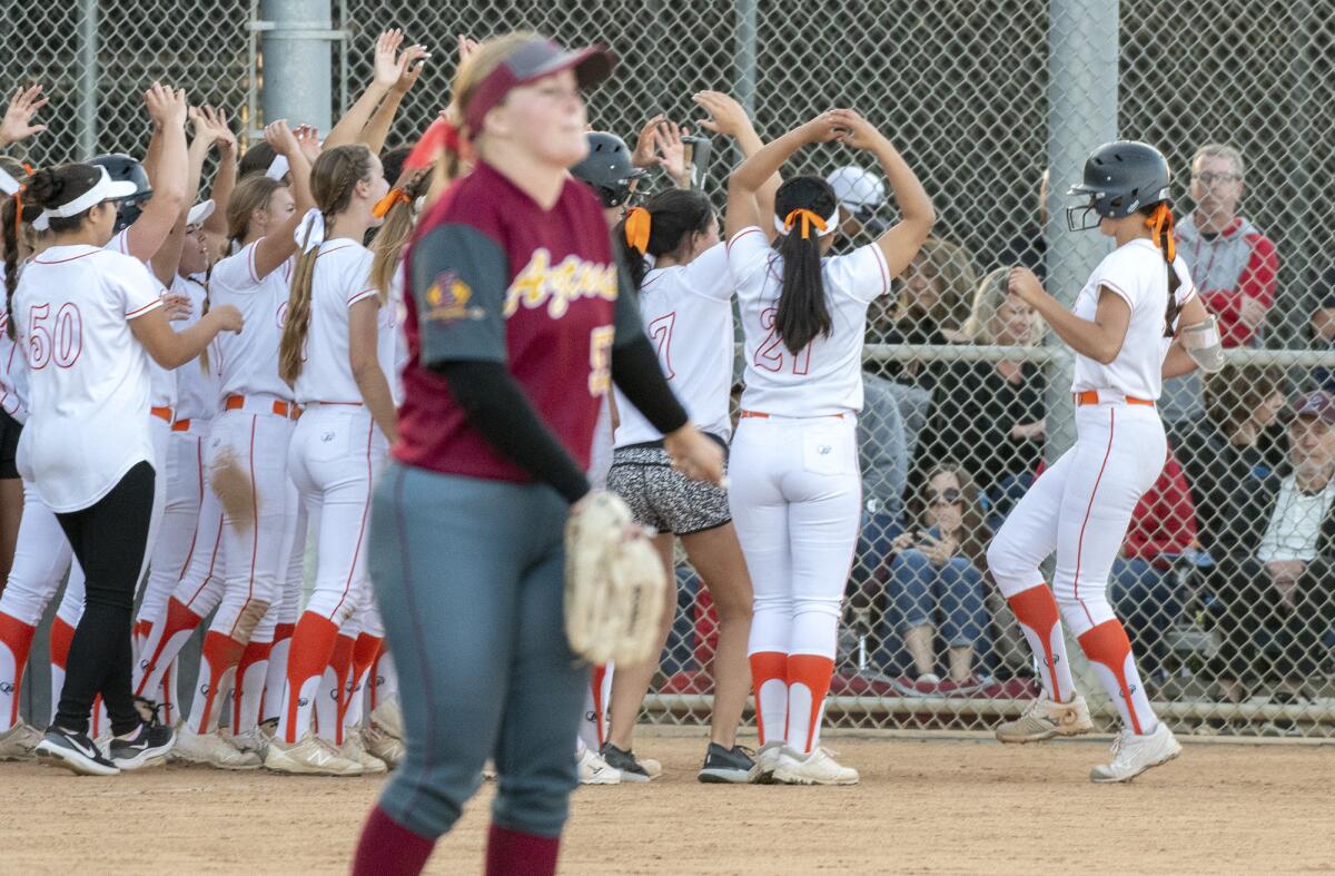 Grace Uribe, right, is met by her Huntington Beach teammates after hitting a home run in the sixth inning of a CIF Southern Section Division 1 second-round playoff game against Esperanza in Huntington Beach on May 7.