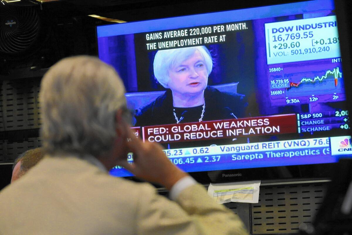 Fed Chairwoman Janet L. Yellen appears on a TV screen at the New York Stock Exchange. The U.S. economy “has been performing well,” she said.