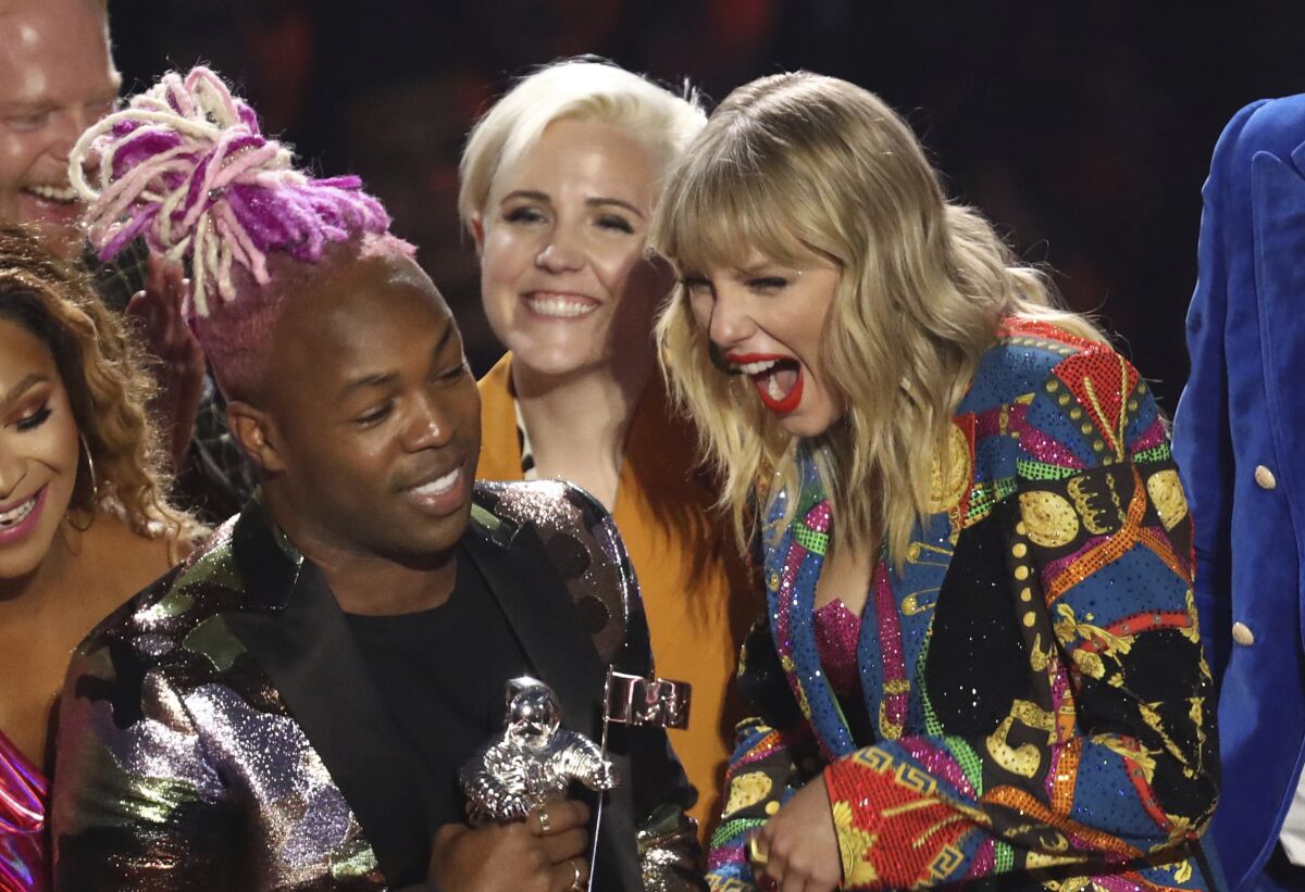 Taylor Swift, right, accepts the Video for Good Award for "You Need to Calm Down" at the MTV Video Music Awards on Monday.