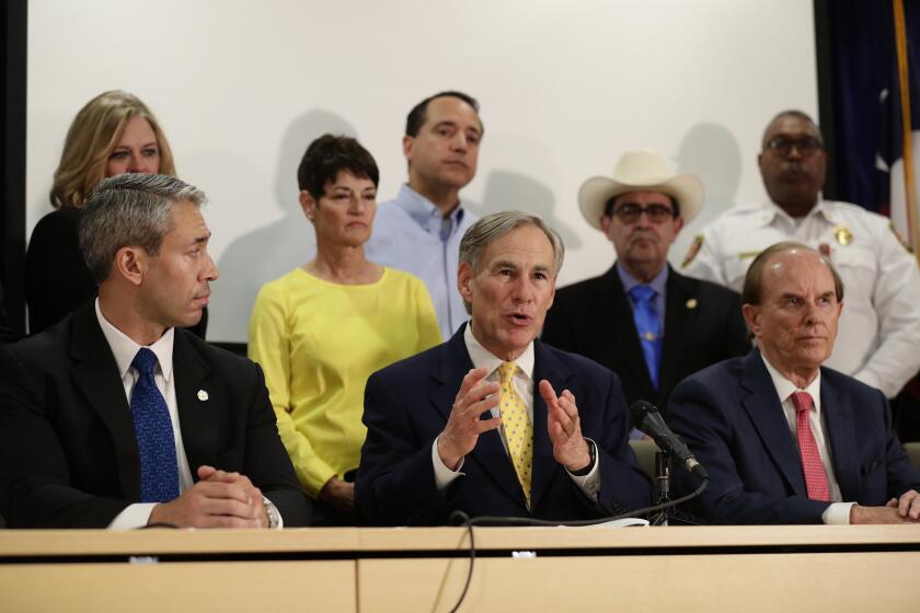 Texas Governor Greg Abbott (center) with other officials in San Antonio on March 16, 2020.