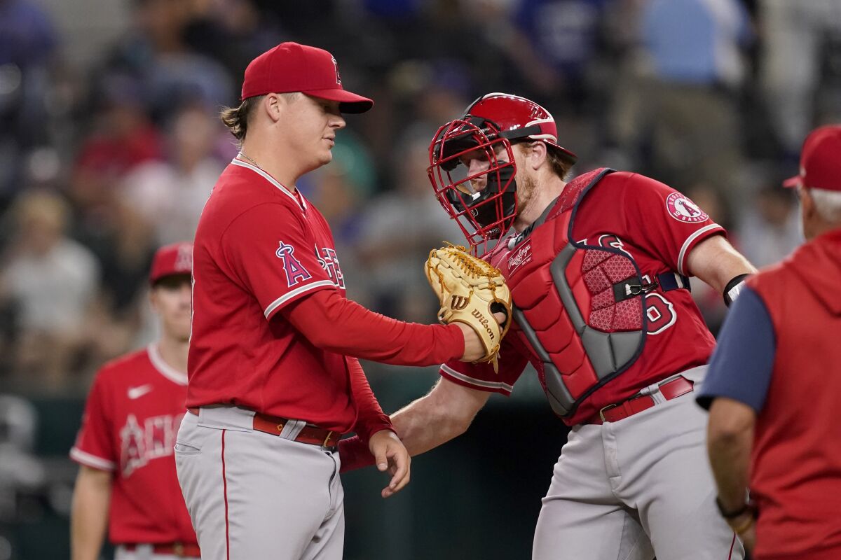 Angels reliever Aaron Loup and catcher Chad Wallach talk on the mound before Loup exits a game against the Texas Rangers.