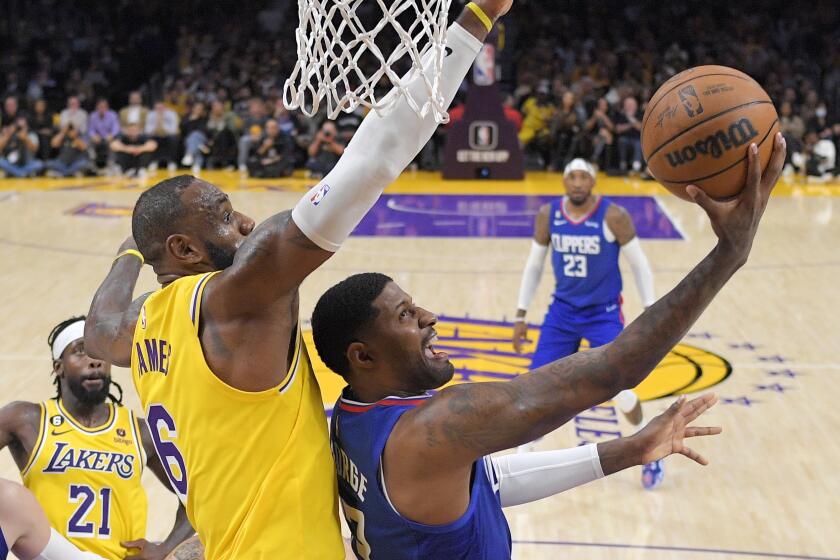 Los Angeles Clippers guard Paul George, right, shoots as Los Angeles Lakers forward LeBron James defends 