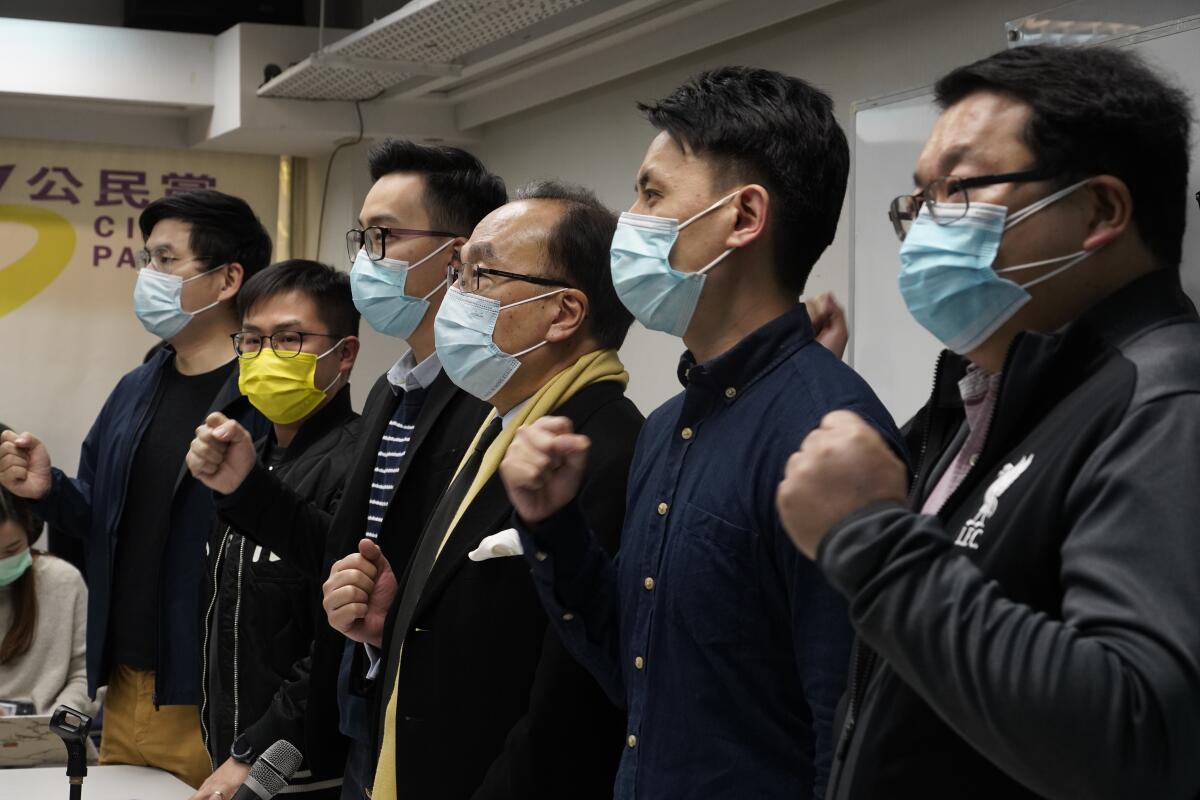 Pro-democratic party members shout slogans in response to the mass arrests during a press conference in Hong Kong.