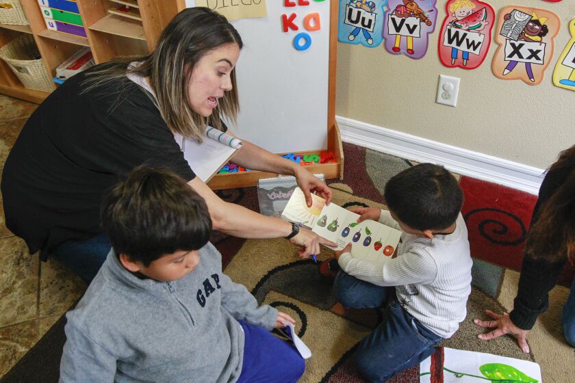 YMCA Childcare Resource Service quality support specialist Marlene Fuentes (left) works with Fidel Sandoval, 4, at a childcare provider residence on May 1, 2019 in Vista, California.