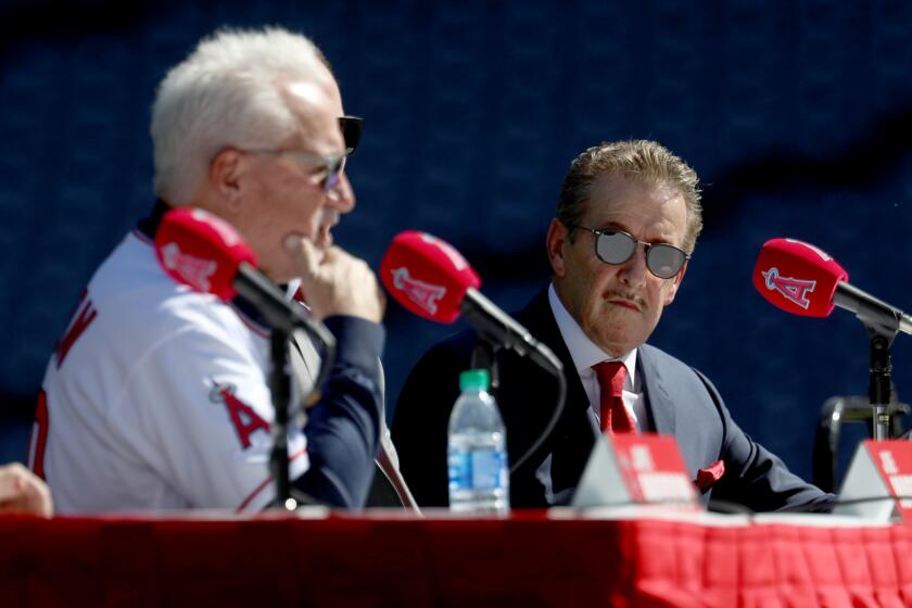 ANAHEIM, CALIF. -- THURSDAY, OCTOBER 24, 2019: Owner Arte Moreno looks on as Joe Maddon, left, addresses the media at a press conference announcing Maddon as the latest manager of the Los Angeles Angels of Anaheim at Angel Stadium in Anaheim, Calif., on Oct. 24, 2019. (Gary Coronado / Los Angeles Times)