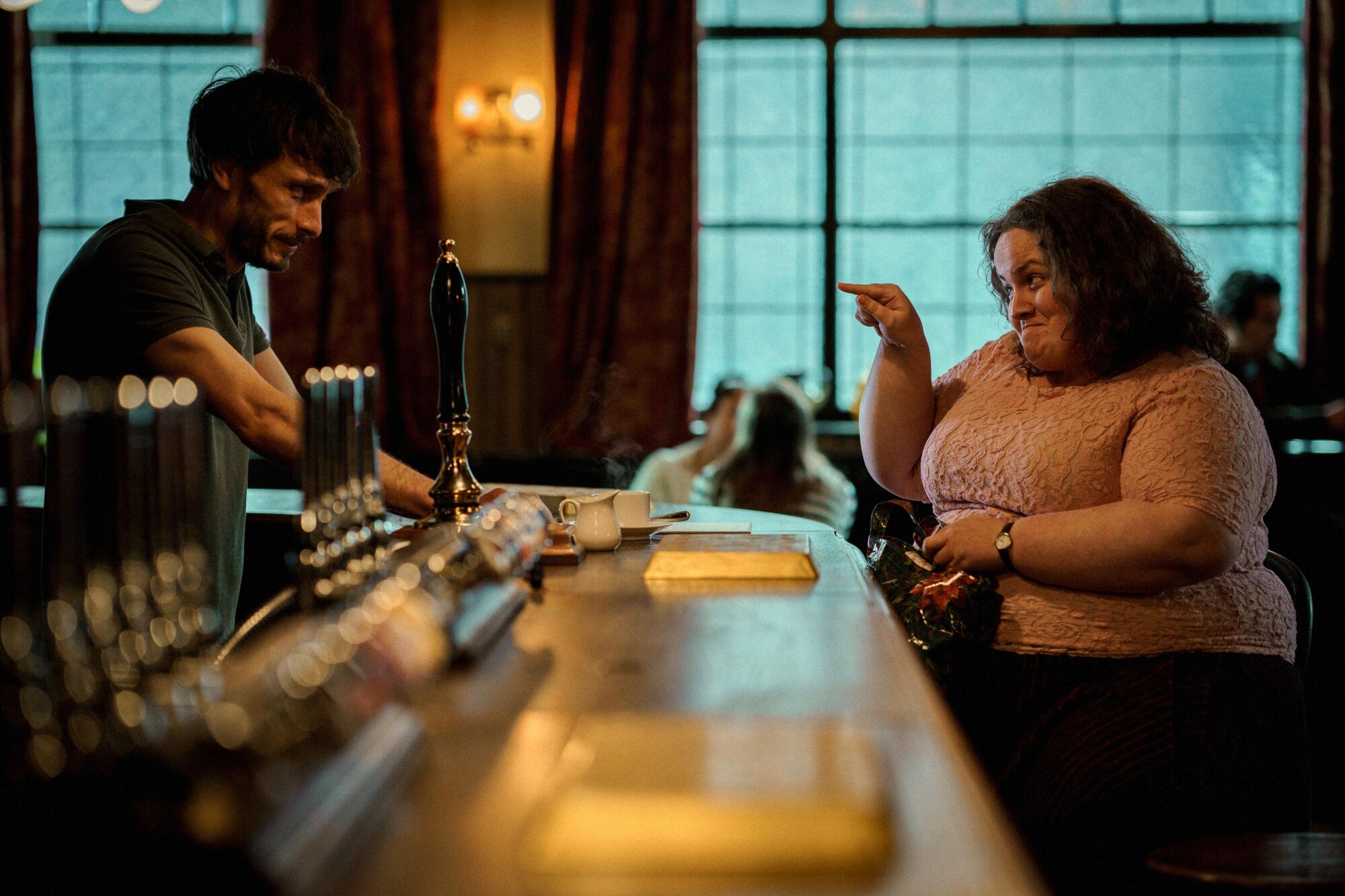 A bartender chats with a customer in a scene from "Baby Reindeer."