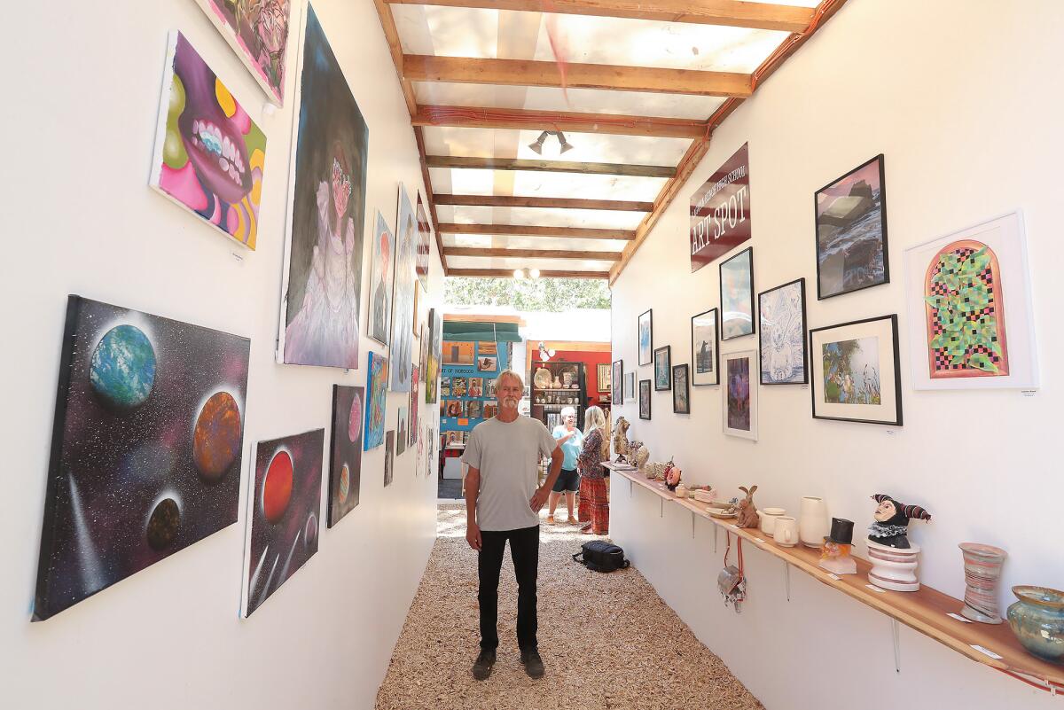 Bud Weir, a local artist and exhibitor, stands in the Laguna Beach High School Art Spot, at the Sawdust Festival.