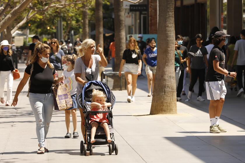 SANTA MONICA, CA - AUGUST 03: Pedestrians of all ages with and without masks walk the Third Street Promenade in Santa Monica Tuesday, August 3, 2021 as Californians and visitors react to the grey space we're in with COVID, lax restrictions and breakthrough cases. Third Street Promenade on Tuesday, Aug. 3, 2021 in Santa Monica, CA. (Al Seib / Los Angeles Times).