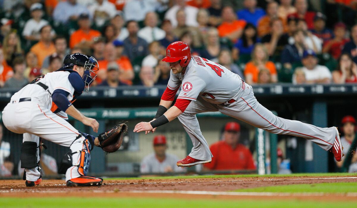 Angels' Jett Bandy slides around the tag of Houston Astros catcher Jason Castro to score in the third inning on Wednesday.