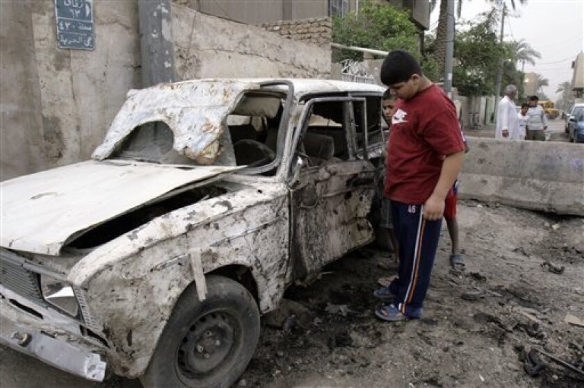 Children check the damage on a car destroyed by a car bomb explosion in Baghdad's Shiite stronghold of Hurriyah, Iraq, Thursday, April 30, 2009. A parked car bomb apparently targeting an Iraqi army patrol exploded late Wednesday in the northern Shiite stronghold of Hurriyah, killing two people and wounding eight others, police said. (AP Photo/Loay Hameed)