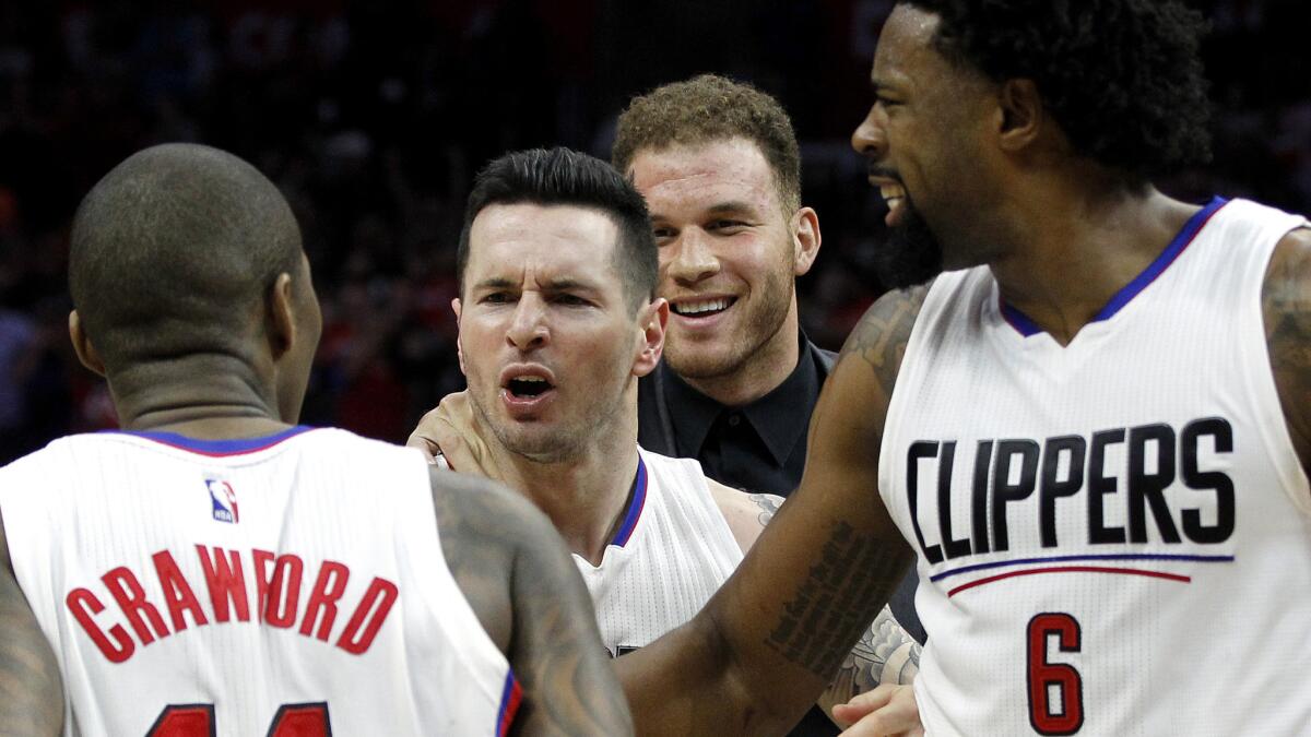 Clippers guard J.J. Redick, center, is congratulated by teammates Jamal Crawford, DeAndre Jordan (6) and Blake Griffin after making the game-winning shot against the Trail Blazers on Thursday.