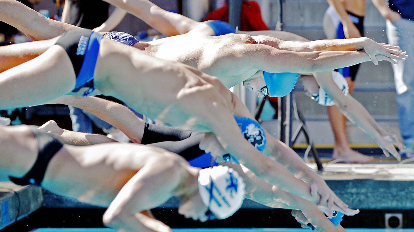 Crescenta Valley's Joseph Langley, top in light blue cap, takes off at the start of the 200 yard freestyle and swims it to win it in a Pacific League dual swim meet between Burbank and Crescenta Valley at Burbank High School on Wednesday, March 28, 2018. Crescenta Valley boys and girls both won the meet.