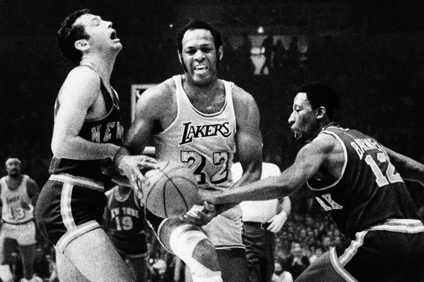 Los Angeles Lakers' Elgin Baylor maneuvers his way through New York Knicks' Bill Bradley