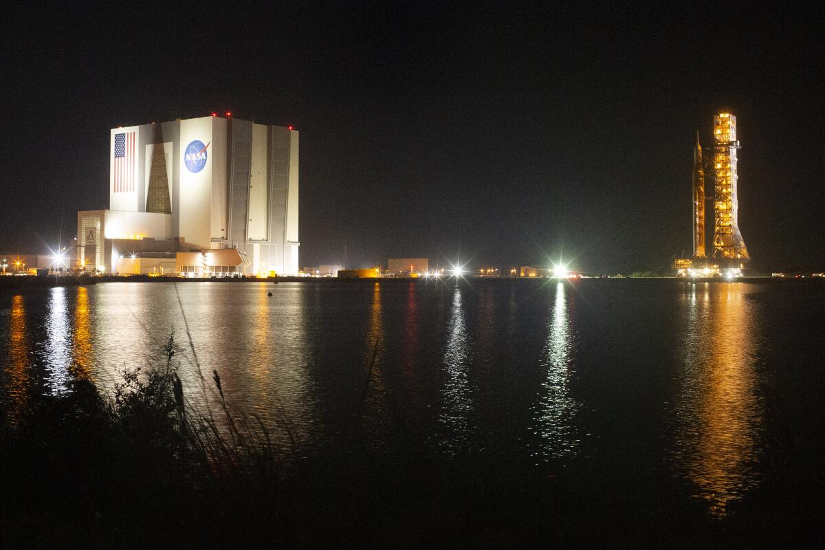 The Space Launch System rocket with the Orion spacecraft is atop the mobile launcher at the Kennedy Space Center at night