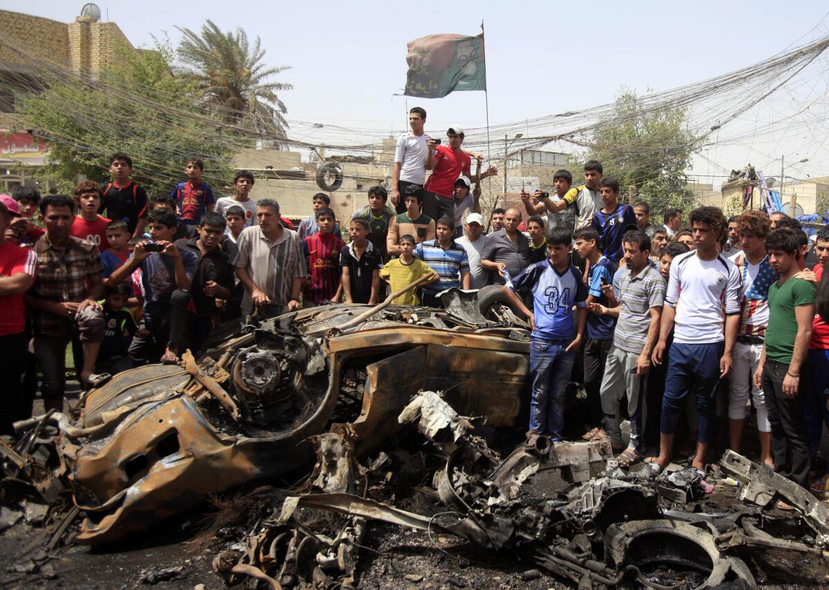 Residents gather at the scene of a car bombing in the Sadr City neighborhood in Baghdad. Nine people were killed in that attack, including a 7-year-old child, and 16 were wounded, two officers said.