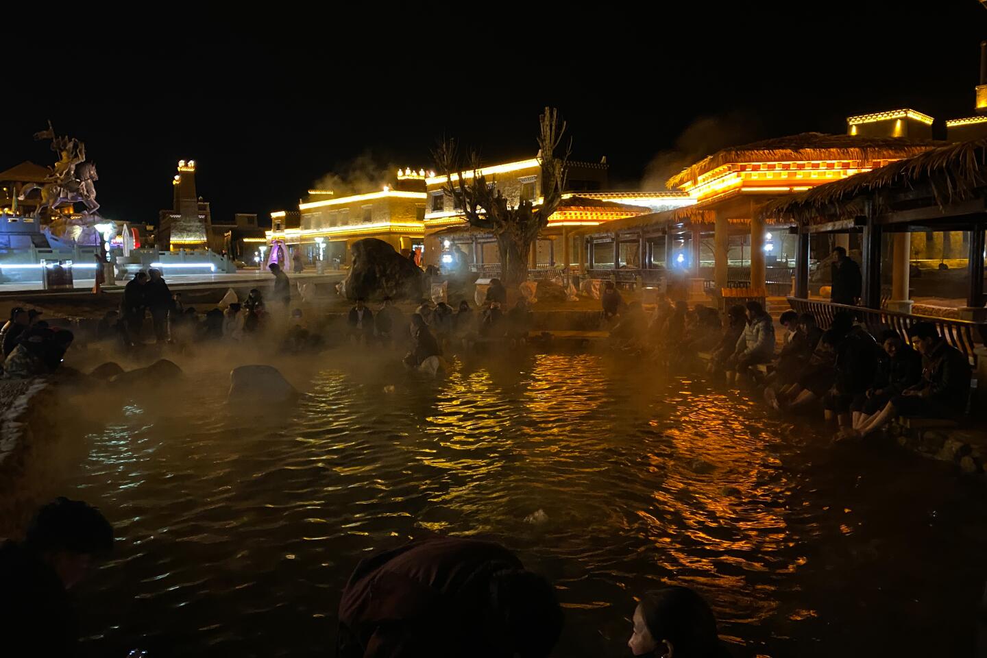 Local people gather around a hot spring, dipping their feet in together in Garze city on Jan. 19, 2020.